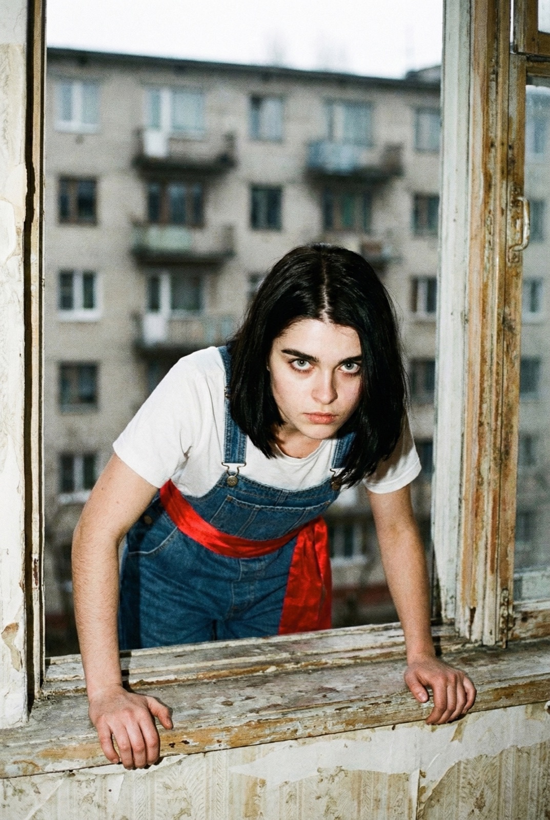 Julia with the red sash leaning out of a decaying window